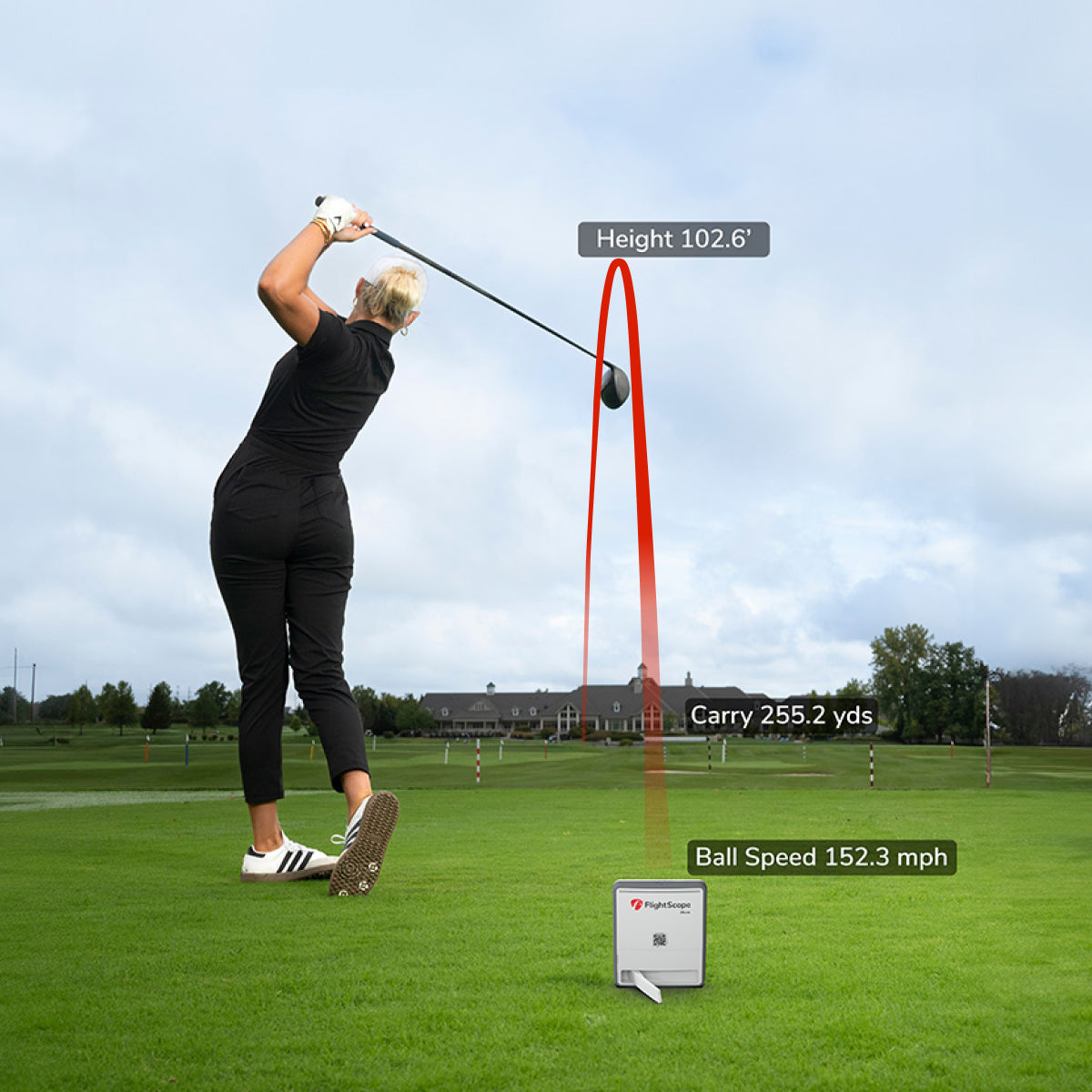 Person playing golf on a green field with digital display showing performance metrics.
