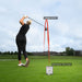Person playing golf on a green field with digital display showing performance metrics.