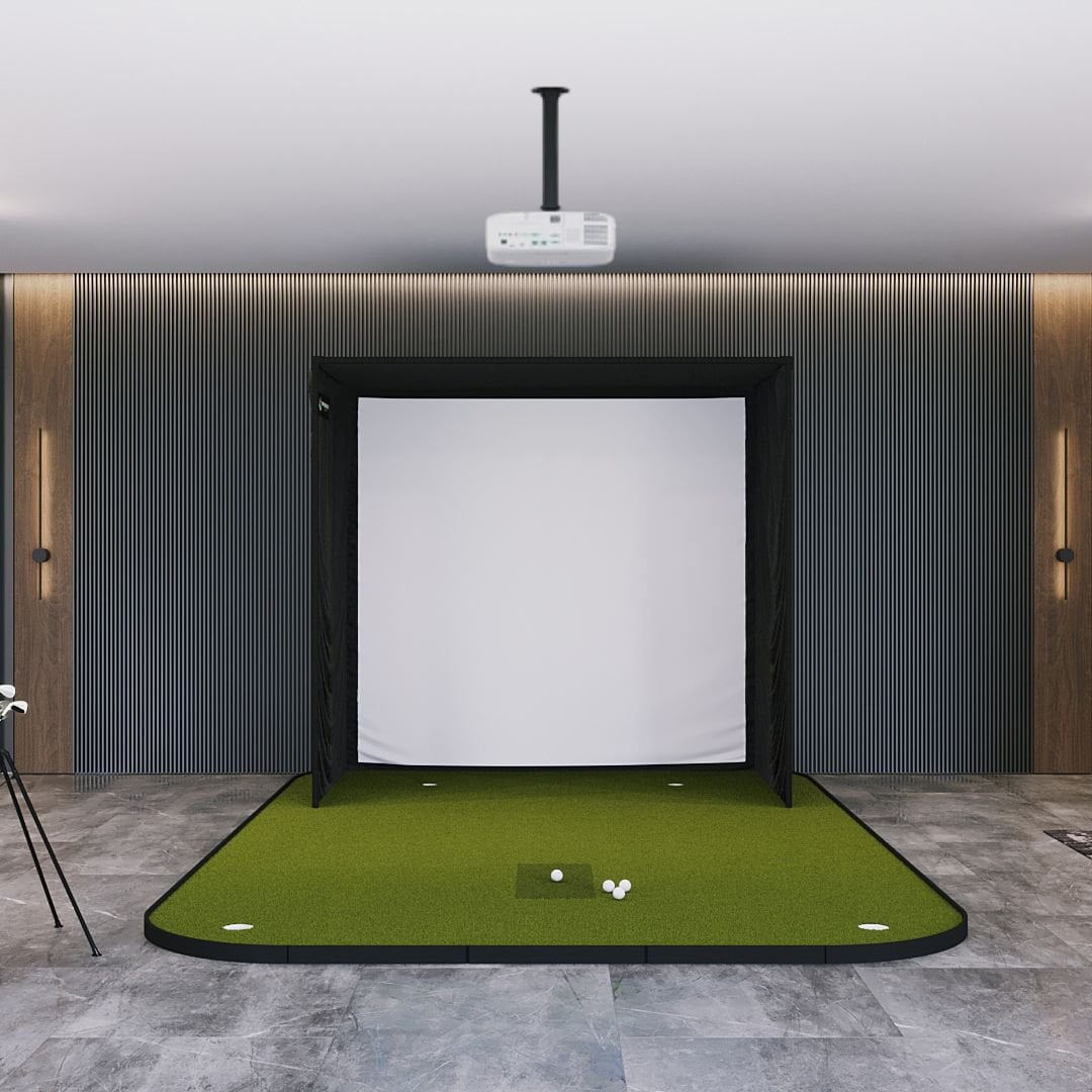 Golf practice simulator with green mat and white screen in a room with wooden walls.